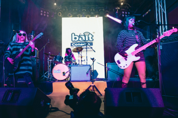 Mujeres jóvenes, pertenecientes a una banda de rock, tocando