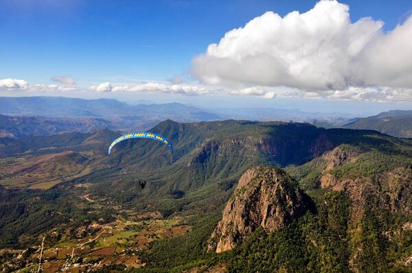 Vista del Peñón de Valle de Bravo con un paracaidísta de fondo
